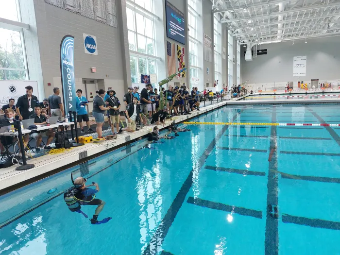 Competitors at the 25th Annual RoboSub competition prepare to test their autonomous underwater vehicles (AUVs) in a swimming pool July 31, 2022, at College Park, Maryland. RoboSub is an international robotics competition, where student teams design, build, test and operate their own robotic submarines— autonomous underwater vehicles (AUVs)—in challenging underwater environments. (Courtesy Photo)