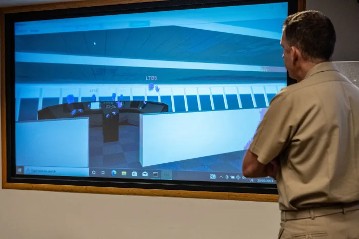 Capt. Andy Berner, ONR Global commanding officer, observes a screen view of the virtual bridge simulator during a test of the commercially available application. 