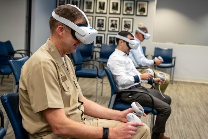 Capt. Andy Berner, ONR Global commanding officer, tries out a commercially-available bridge simulator identified by the London Tech Bridge, ONR Global..