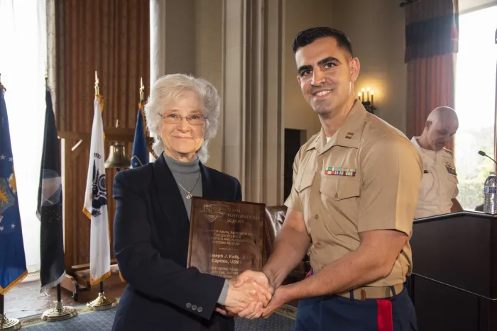 Retired Vice Adm. Ann E. Rondeau, Naval Postgraduate School (NPS) president, presents Marine Corps Capt. Joseph J. Kelly Jr. (right) with a Chief of Naval Research (CNR) Award for Excellence in Intelligent Autonomous Systems. The award honors NPS students performing outstanding academic work related to autonomous systems. (Photo: Naval Postgraduate School)