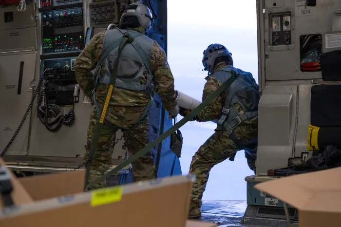 Alaska Air National Guard Senior Master Sgt. Cecil Dickerson, left, observes as Master Sgt. Tony Johnson, center, and Master Sgt. John Massi, all C-17 Globemaster III loadmasters assigned to the Alaska Air National Guard’s 144th Airlift Squadron at JBER, deploy Ice Ball and CryOS buoys during an airdrop mission over the Arctic Ocean, Jan. 30, 2025. (Alaska Air National Guard photo by Staff Sgt. Daniel Bellerive)