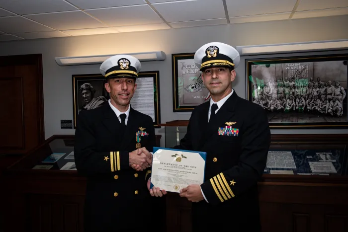 ONR Global Capt. Matthew Romero, TechSolutions outreach coordinator (right), presents Lt. Cmdr. Geoffrey Dick with the Navy and Marine Corps Achievement Medal for his leadership in championing, prototyping and transitioning to operations the TechSolutions TS-944 T-45 Mixed Reality (MR) Trainer at Naval Air Station Corpus Christi, Texas. (U.S. Navy photo by Morgan Galvin)