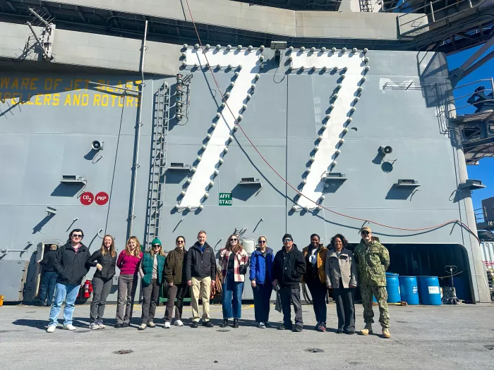 A group of 12 scientists, engineers, oceanographers and mathematicians pose for a photo following a tour aboard U.S.S. George H.W. Bush (CVN 77) in Norfolk, Virginia, as part of the Office of Naval Research Global’s Scientist-to-Sea initiative. S2S provides an opportunity for stakeholders to gain an in-depth understanding of the naval operations. (Courtesy Photo)