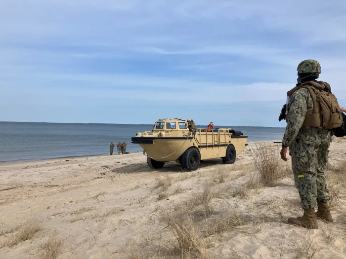 A warfighter views a beach landing of a Lighter, Amphibious, Resupply, Cargo vehicle during a demonstration for scientist and engineers participating in the Office of Naval Research Global’s Scientist-to-Sea initiative. S2S provides an opportunity for stakeholders to gain an in-depth understanding of the naval operations. (U.S. Navy photo by Cmdr. Jeff Parks)