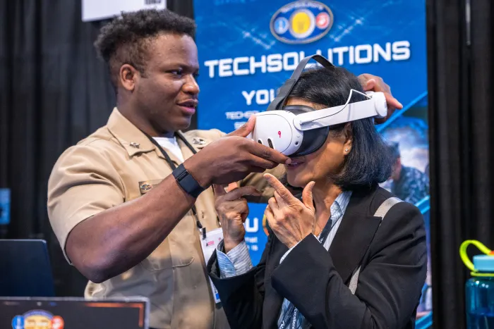 ONR GLOBAL TechSolutions Fleet Engagement Coordinator MMN1 Fonanti Sapee speaks to ONR's Chief of Naval Research Rear Adm. Kurt Rothenhaus at Modern Day Marine 2025. (U.S. Navy photo by Michael Walls)