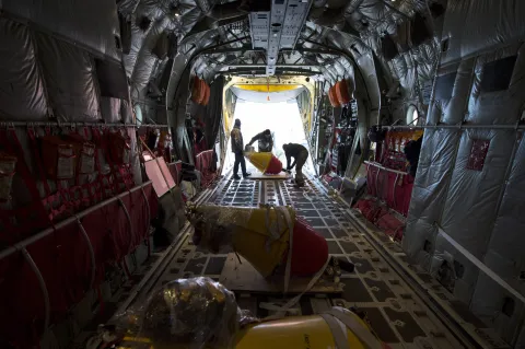 Aircrew load an Air-Deployable Expendable Ice Buoy (AXIB) aboard a Royal Danish Air Force C-130 aircraft at Thule Air Force Base in Greenland, in preparation for deployment in the high Arctic as part of the International Arctic Buoy Program (IABP).