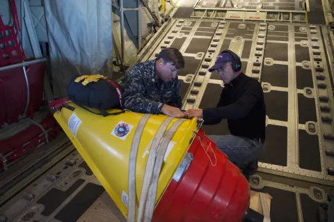 Lt. Cmdr. John Woods, Office of Naval Research (ONR) reserve component, and Ignatius Rigor, University of Washington, prepare an Air-Deployable Expendable Ice Buoy (AXIB) for deployment in the high Arctic near the North Pole from a Royal Danish Air Force C-130 aircraft operating out of Thule Air Force Base in Greenland, as part of the International Arctic Buoy Program (IABP).