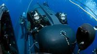 Members of SEAL Delivery Vehicle Team Two (SDVT-2) prepare to launch one of the team's SEAL Delivery Vehicles (SDV) from the back of the Los Angeles-class attack submarine USS Philadelphia (SSN 690) on a training exercise.