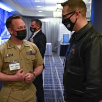 Naval Junior Officer Counsel (NJOC) Director Lt. John-Rex Spivey (left) discusses NJOC with an attendee at the 34th Surface Naval Association Symposium earlier this year. NJOC is a management advisory group designed to bridge the communications gap between junior and senior leaders. It recently launched a new online discussion tool — called the Acceleration Series — for sharing ideas, insights and concerns with senior leadership. (U.S. Navy photo by Michael Walls)