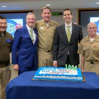 Rear Adm. Kurt Rothenhaus (right), celebrates the 1,000th request sent to TechSolutions — along with the director of TechSolutions, Jason Payne (center right); Capt. Andy Berner (center), commanding officer, ONR Global; John Coffey (center left), TechSolutions; and Command Master Chief Andrew Chupashko (left) — at ONR headquarters in Arlington, Virginia. (U.S. Navy photo by Michael Walls)