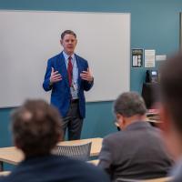 Scott Bewley, NavalX’s deputy director of business operations, addresses attendees at the 2024 Naval Science and Technology (S&T)/Combat Systems/Technology, Systems and Ships Symposium held Dec. 9-12 in Arlington, Virginia. (U.S. Navy photo by Michael Walls)