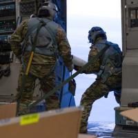 Alaska Air National Guard Senior Master Sgt. Cecil Dickerson, left, observes as Master Sgt. Tony Johnson, center, and Master Sgt. John Massi, all C-17 Globemaster III loadmasters assigned to the Alaska Air National Guard’s 144th Airlift Squadron at JBER, deploy Ice Ball and CryOS buoys during an airdrop mission over the Arctic Ocean, Jan. 30, 2025. (Alaska Air National Guard photo by Staff Sgt. Daniel Bellerive)