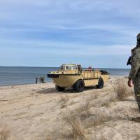 A warfighter views a beach landing of a Lighter, Amphibious, Resupply, Cargo vehicle during a demonstration for scientist and engineers participating in the Office of Naval Research Global’s Scientist-to-Sea initiative. S2S provides an opportunity for stakeholders to gain an in-depth understanding of the naval operations. (U.S. Navy photo by Cmdr. Jeff Parks)