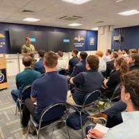 Royal Marine Brigadier Jaimie Roylance, the Royal Navy’s Chief Technology Officer, addresses the audience at the computer vision for maintenance and sustainment hybrid event from Portsmouth Naval Base, U.K. (Courtesy Photo)