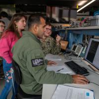 At the Naval Postgraduate School, Naval Research Enterprise Internship Program (NREIP) intern Calla Woodruff Lyons (center, standing) engaged in critical space systems research.